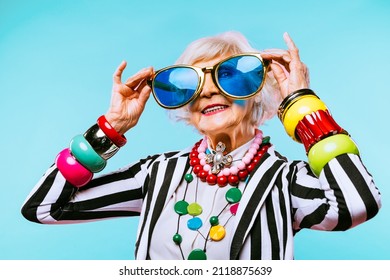 Happy and funny cool old lady with fashionable clothes portrait on colored background - Youthful grandmother with extravagant style, concepts about lifestyle, seniority and elderly people - Shutterstock ID 2118875639