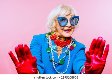 Happy and funny cool old lady with fashionable clothes portrait on colored background - Youthful grandmother with extravagant style, concepts about lifestyle, seniority and elderly people - Shutterstock ID 2195108903