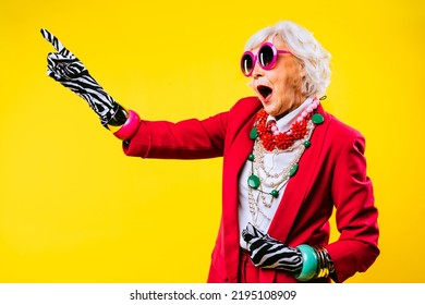 Happy and funny cool old lady with fashionable clothes portrait on colored background - Youthful grandmother with extravagant style, concepts about lifestyle, seniority and elderly people - Shutterstock ID 2195108909