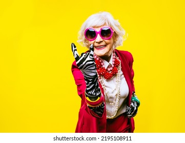 Happy and funny cool old lady with fashionable clothes portrait on colored background - Youthful grandmother with extravagant style, concepts about lifestyle, seniority and elderly people - Shutterstock ID 2195108911