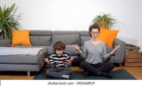 Happy funny and crazy family in apartment ,  mother and son  does yoga meditation gym during Covid-19 Coronavirus lockdown quarantine home - lifestyle in living room - Powered by Shutterstock