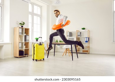 Happy, funny, energetic, excited man office worker in a sun hat, sunglasses and beach ring jumping and having fun in the office. Summer holiday, vacation, work leave, annual leave concept