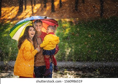 Happy Funny Family With Colourful Umbrella Under The Autumn Rain.