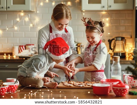 happy funny family mother and children  bake christmas cookies on cozy kitchen at home
