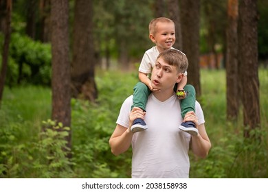 Happy funny kid riding on dads shoulders. Caucasian daddy and son playing together,laughing and having fun. Happy Family activity concept - Powered by Shutterstock