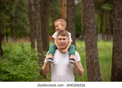 Happy funny kid riding on dads shoulders. Caucasian daddy and son playing together,laughing and having fun. Happy Family activity concept - Powered by Shutterstock