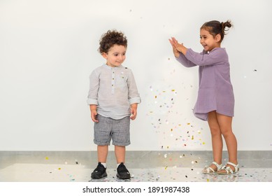 Happy Funny Kids With Confetti On White Background. Little Boy Having Fun Celebrating Birthday. Cute Happy Girl Throwing Confetti, Having Fun In A Party.