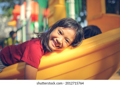 Happy Funny Little Girl Playing Merry Go Around At The Playground Outdoor In The Daytime Summer. Outdoor Activity. Playing Make Believe And Outside Education Concept.