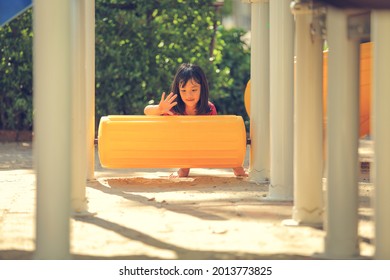 Happy Funny Little Girl Playing Merry Go Around At The Playground Outdoor In The Daytime Summer. Outdoor Activity. Playing Make Believe And Outside Education Concept.