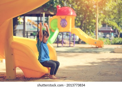 Happy Funny Little Girl Playing Merry Go Around At The Playground Outdoor In The Daytime Summer. Outdoor Activity. Playing Make Believe And Outside Education Concept.