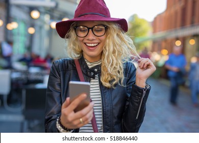 Happy and funny woman looking at her phone