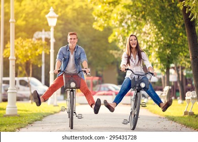 Happy funny young couple riding on bicycle