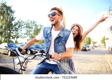 Happy funny young couple riding on bicycle. Love, relationship, romance concept.