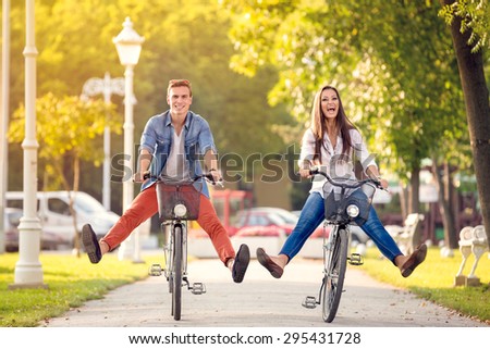 
Happy funny young couple riding on bicycle