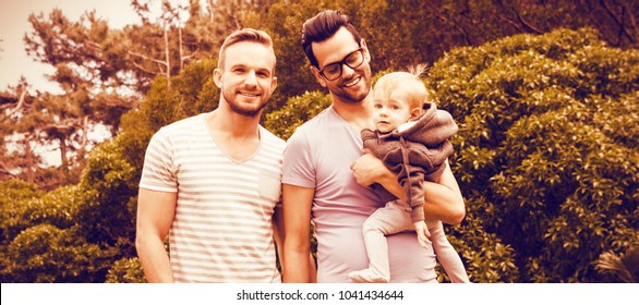 Happy Gay Couple With Child In Garden