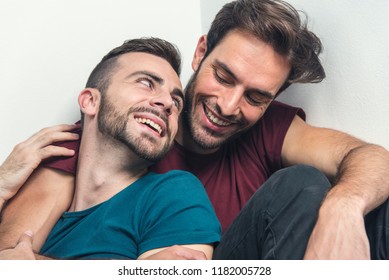 Happy gay couple embraced, joking and having fun in an intimate hug