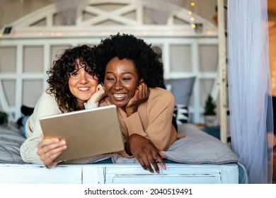 Happy Gay Couple Looking At Digital Tablet Together At Home