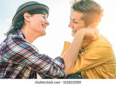 Happy gay couple looking at each other hand to hand - Young women lesbians having a tender moment outdoor - Lgbt, bisexuality, relationship lifestyle concept  - Powered by Shutterstock