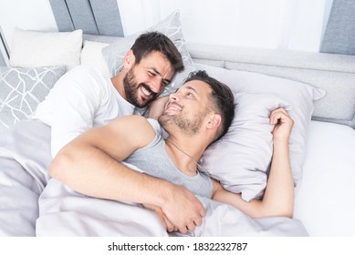 Happy Gay Couple Looking At Each Other With Love In Bed