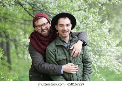 Happy Gay Couple Posing On Blurred Spring Background