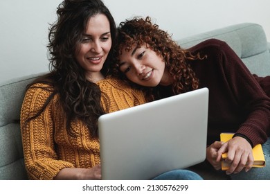 Happy Gay Couple Of Women Having Fun Using Computer Laptop At Home - LGBT Lesbian Relationship Concept - Focus On Left Girl Face