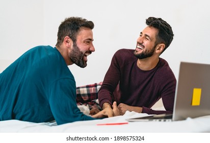 Happy Gay Men Couple Using Laptop In Bed - Love And Gender Equality In Relationship Concept