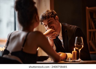 happy gentleman in elegant attire kissing hand of girlfriend during date on Valentines day - Powered by Shutterstock