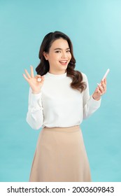 Happy Gesturing Young Cheerful Smiling Business Woman With Phone Or Support Operator, Showing Okay Gesture, 