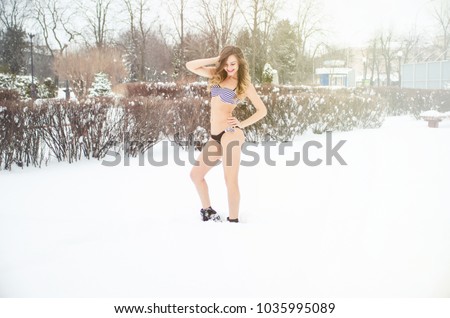 Happy girl in bikini posing in snow