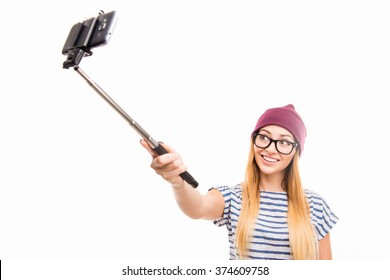 Happy Girl In Cap And Glasses Making Photo By Selfie Stick