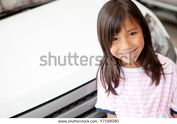 Happy girl at a car dealer\
smiling