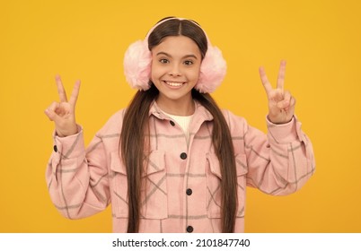 Happy Girl Child Smile In Warm Winter Fur Earmuffs Gesturing Double V Signs Hand Gesture, Victory