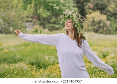 Happy girl dancing in chamomile flower wreath at natural meadow outdoors - Powered by Shutterstock