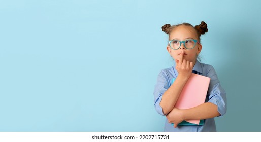 Happy girl with Down syndrome having fun in the studio with books. Banner - Shutterstock ID 2202715731