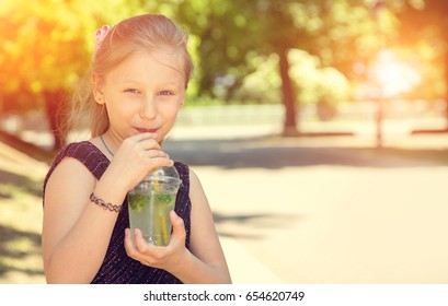 Happy Girl Drinks Ice Cold Drink On A Hot Day In The Park. Summer Chilled Drinks. Copy Space.