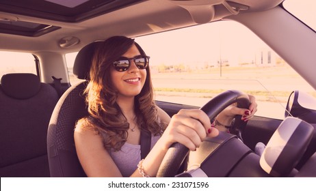 Happy Girl driving at sunset. Picture with filters and vintage effects, 16:9 format. - Shutterstock ID 231071596