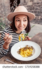 Happy Girl Eating A Traditional Tuscan Delicacy - Pasta Noodles With Fresh Mushrooms And Truffles. You'll Lick Your Fingers!