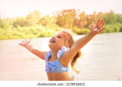 Happy Girl Enjoying Nature With Hands Raised In Sky By Beach. Hands Messy Of Sand