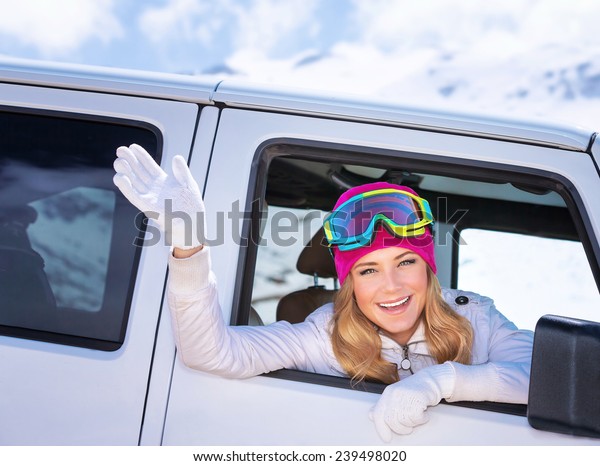 Happy girl enjoying\
winter sports, cheerful portrait of a woman sitting in the car and\
wearing ski mask, arrived to alpine ski resort, tourist travel on\
Christmas holidays