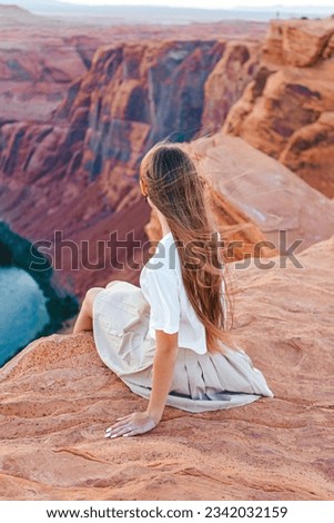 Happy girl at the famous Horseshoe Bend in Page Canyon with stunning views of the Colorado River, Arizona. Adventure and tourism concept.
