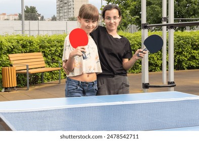 Happy girl friends playing ping pong table tennis, having fun together - Powered by Shutterstock