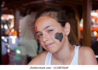 Happy Girl With Funny Expression. Heart And Scar Are Painted On The Face