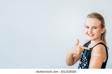 Happy Girl Giving Thumb Up And Showing Her Arm With Bandage After Got Vaccinated, Child Immunization, Covid Delta Vaccine