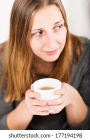 Happy Girl In Grey Holding Mug And Not Looking At Camera With Smile