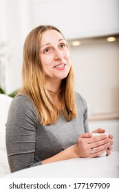 Happy Girl In Grey Holding Mug And Not Looking At Camera With Smile