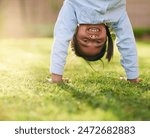 Happy, girl and handstand with grass in park for playing, sunshine and having fun outdoors. Nature, weekend and portrait with smile in playground for relaxing, childhood and upside down in summer