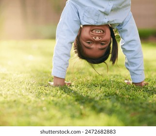 Happy, girl and handstand with grass in park for playing, sunshine and having fun outdoors. Nature, weekend and portrait with smile in playground for relaxing, childhood and upside down in summer