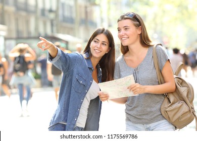 Happy girl helping to a tourist who asks direction in the street - Shutterstock ID 1175569786
