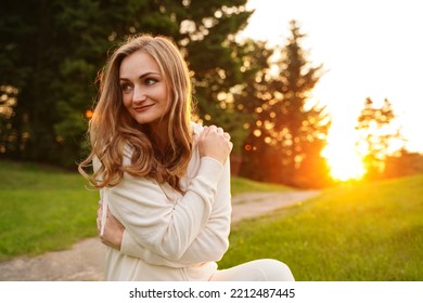 Happy girl hugging herself with love at sunset. Beautiful woman in nature. The concept of self-esteem love of life attitude. Place for your affirmation - Shutterstock ID 2212487445