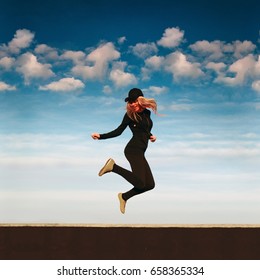 Happy girl jumping on the roof in sunny day - Shutterstock ID 658365334